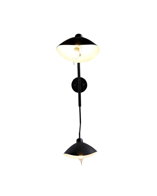 Fleur de Noir Wall Sconce with a matte black finish, featuring an elongated sculptural arm and two opposing dome-shaped shades, shown illuminated against a white background.