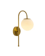 Wall-mounted brass light fixture with a curved arm and a glowing spherical white glass shade.