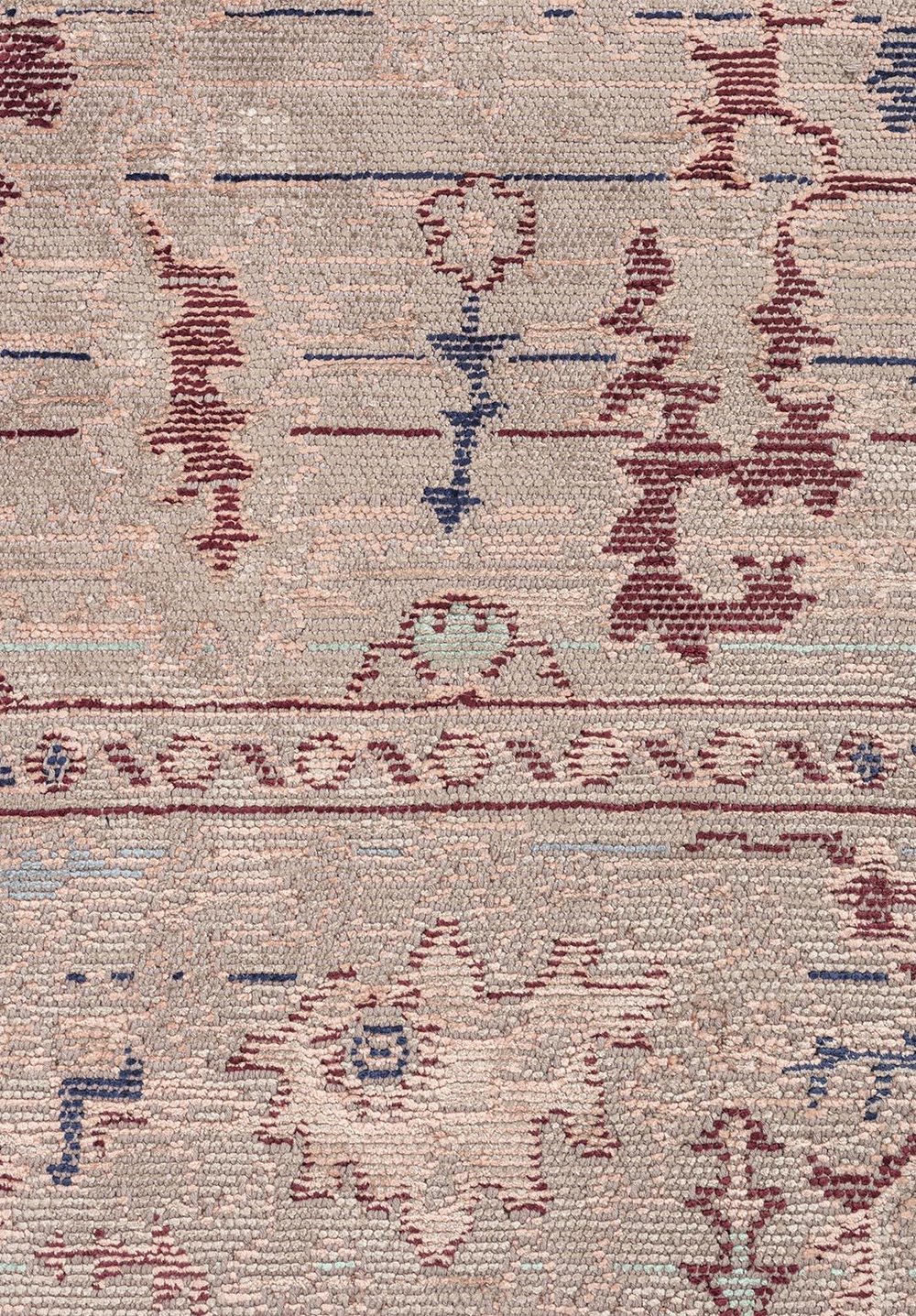 Close-up of a traditional rug pattern with muted geometric and floral details.
