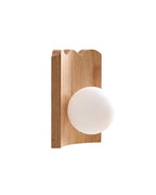 Clemence wall sconce featuring an oak wood backplate with a protruding white glass globe, shown from a side angle.