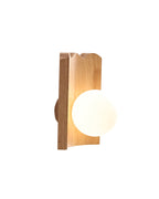 Clemence wall sconce with an oak wood backplate and illuminated white glass globe, shown in side profile.