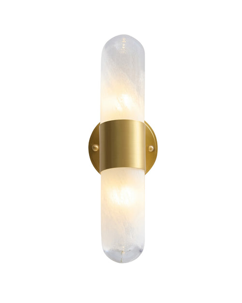 Vertical brass wall sconce with a softly glowing textured glass cylinder, secured at the center by a brushed brass band and mounted on a round brass backplate, emitting warm ambient light.