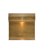 Wall-mounted light fixture with a perforated cylindrical metal shade attached to a curved rectangular brass backplate.