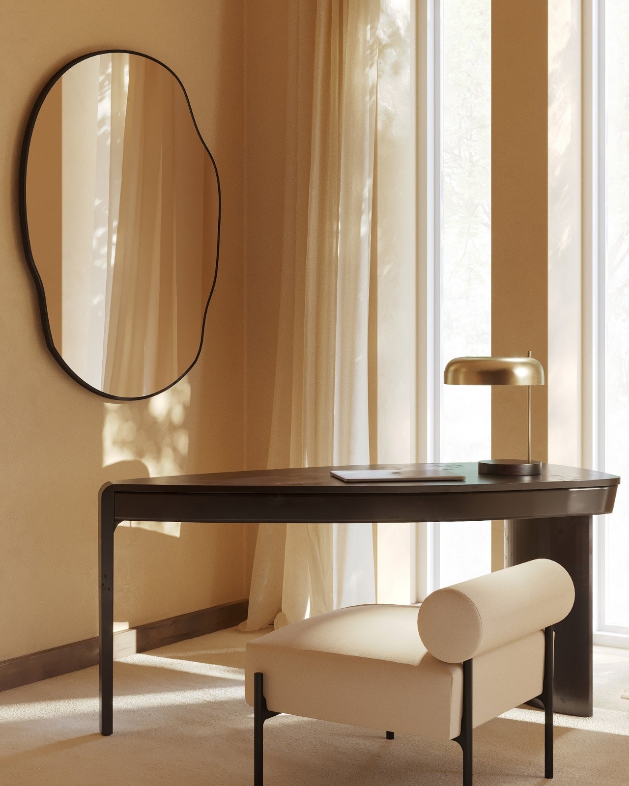 Irregular-shaped wall mirror with a slim dark frame mounted above a modern desk, reflecting sheer curtains and natural daylight.