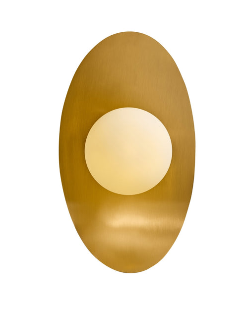 Wall-mounted light featuring a centered opaque white glass globe set against a vertically oriented oval brass backplate, shown on a white background.