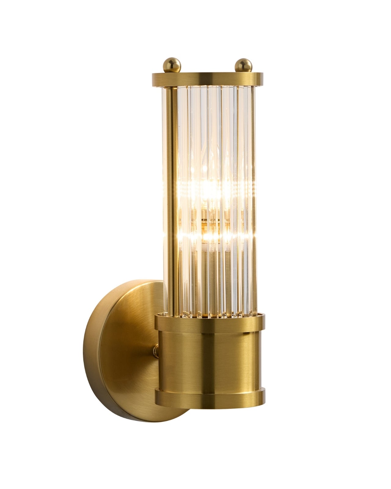 Wall-mounted brass sconce with a cylindrical clear glass shade featuring vertical ribbed texture, shown illuminated against a white background.