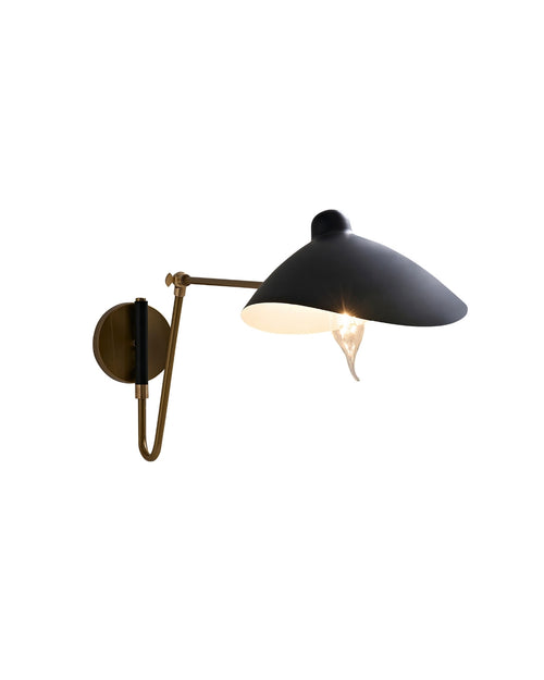 Side view of a wall-mounted sconce with a black dome-shaped shade, brass arm and wall plate, and an exposed bulb beneath the shade, shown against a white background.