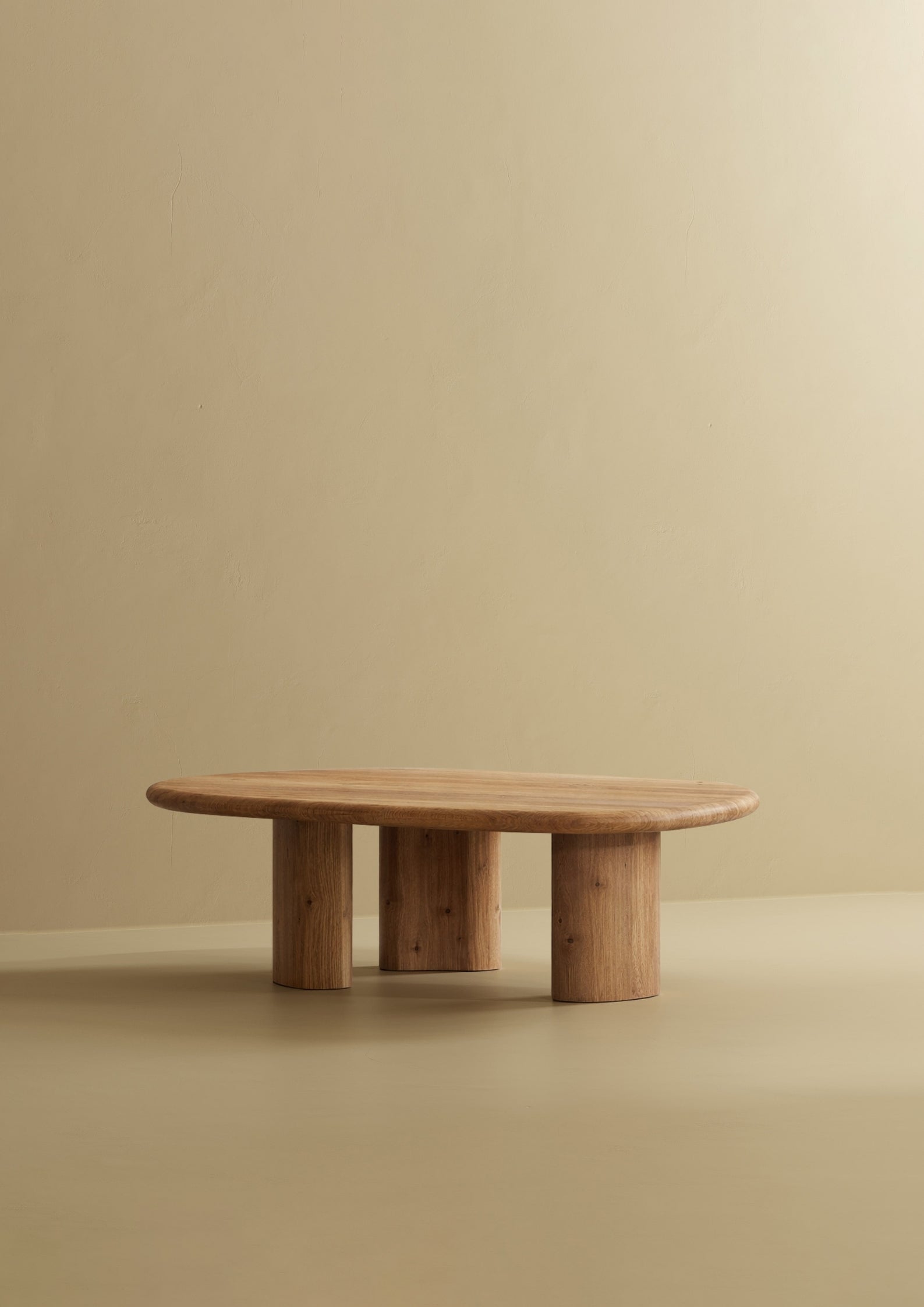 A low solid wood coffee table with an organic-shaped top and rounded legs.