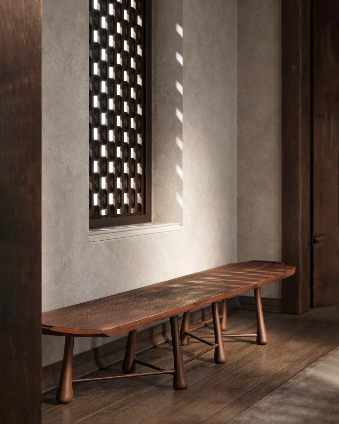 Long wooden bench with sculpted legs in a warm-toned interior with natural light.