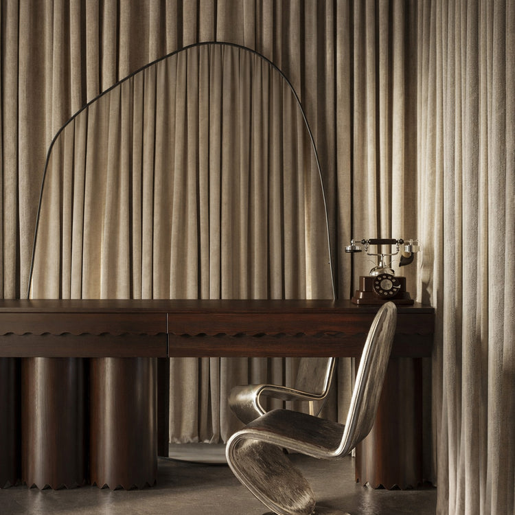 XXL organic wall mirror with black frame positioned above a dark wood desk with a chair and rotary phone.