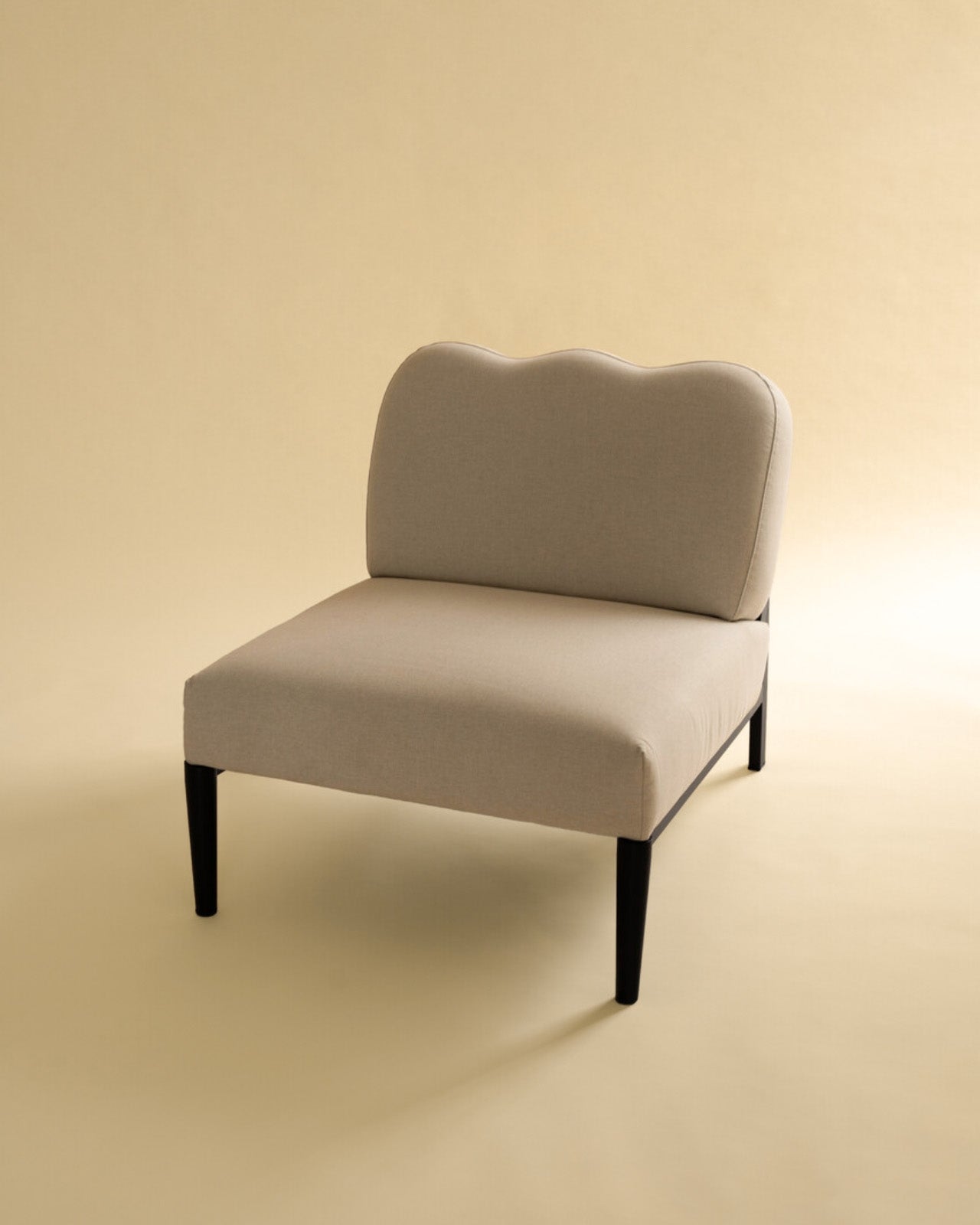 Beige linen upholstered accent chair with a curved backrest and black metal legs.