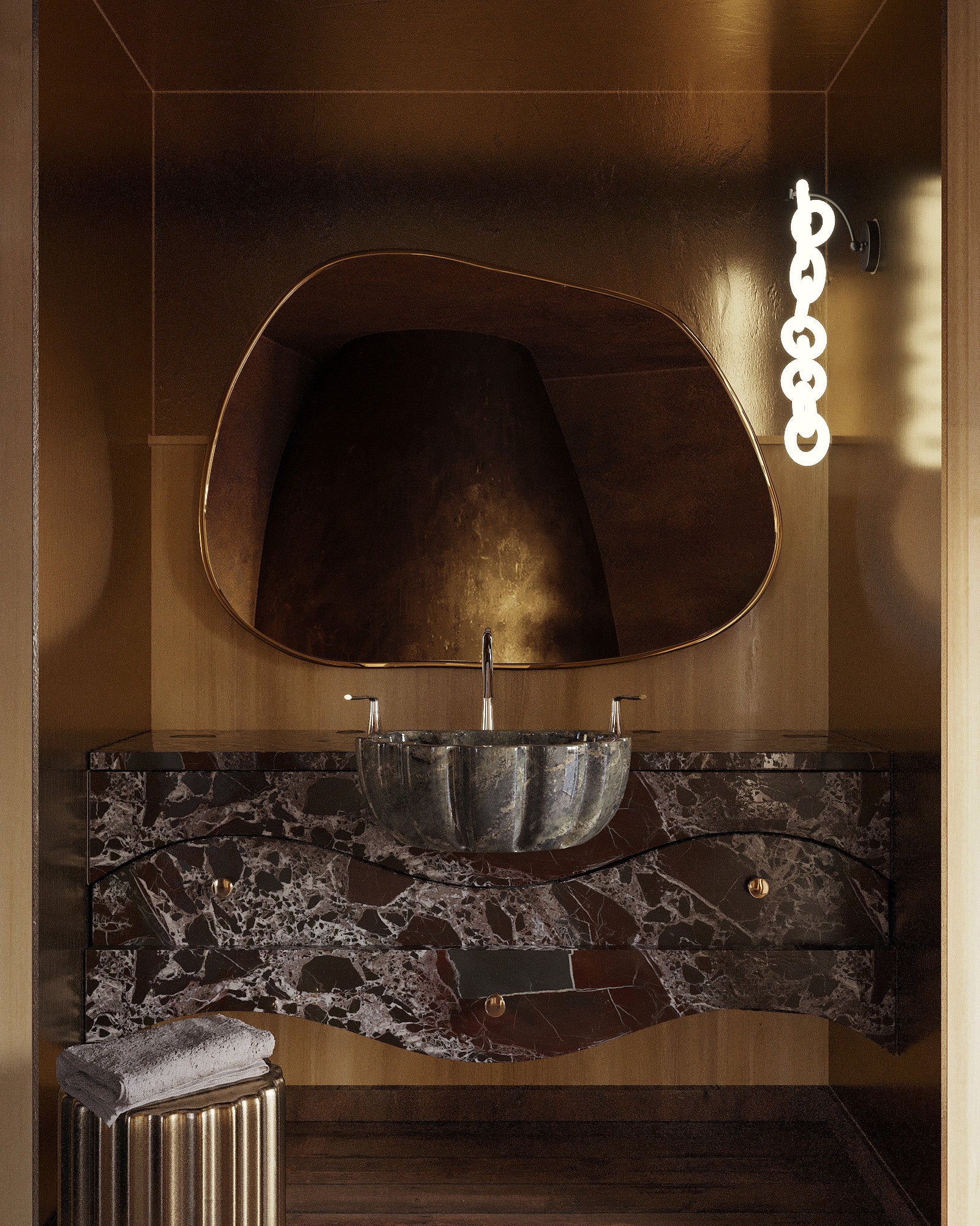 Asymmetrical brass-framed mirror mounted above a marble bathroom vanity with a vessel sink and wall light.