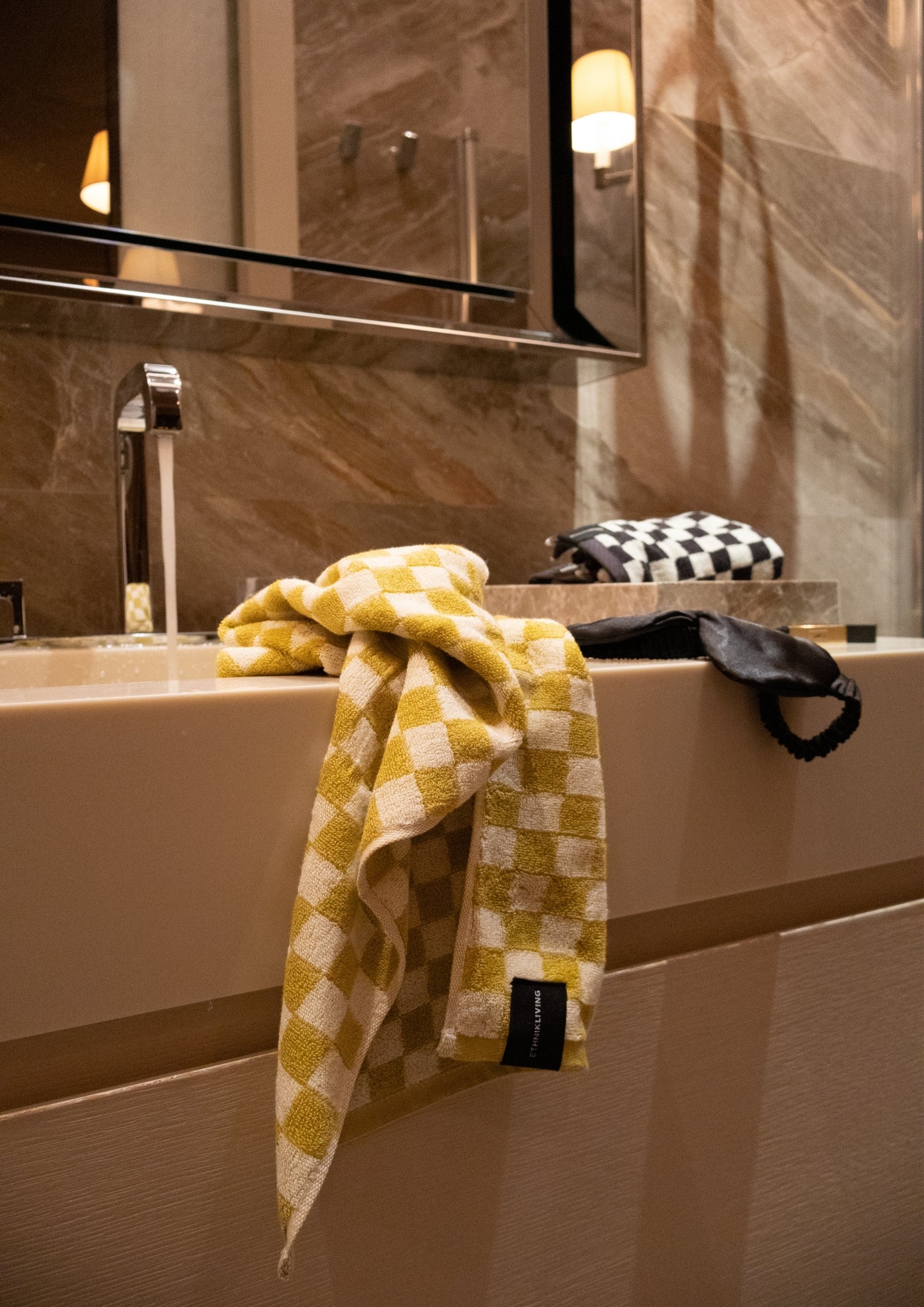 Yellow checkered towel draped over a bathroom sink.