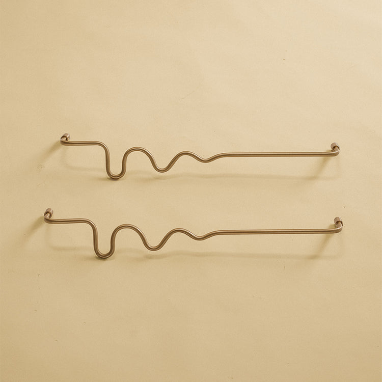 Two brass wavy towel bars displayed on a neutral studio background.