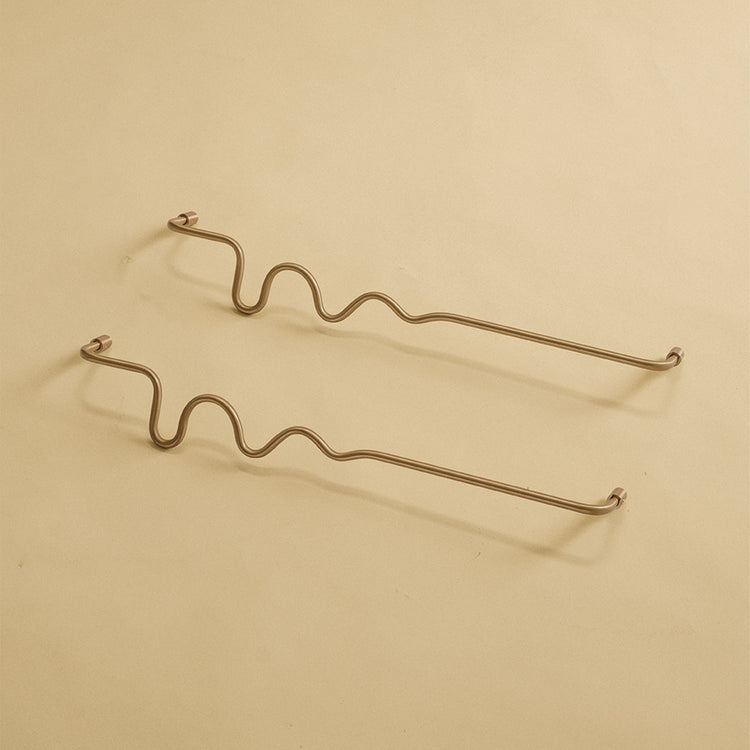 Two brass wavy towel bars displayed on a neutral studio background.