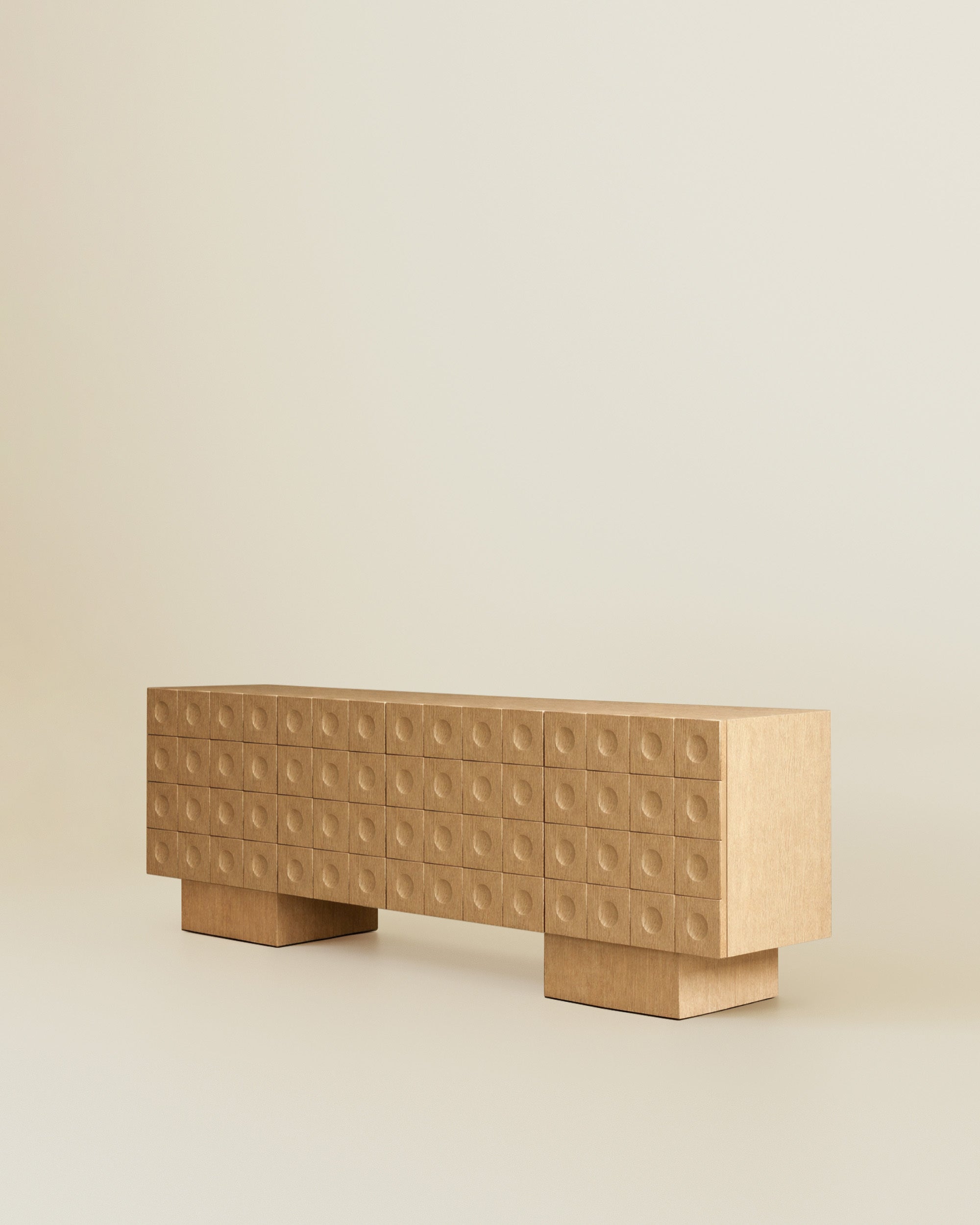 Angled view of a modern wood sideboard with circular indented drawer fronts on a neutral beige background.