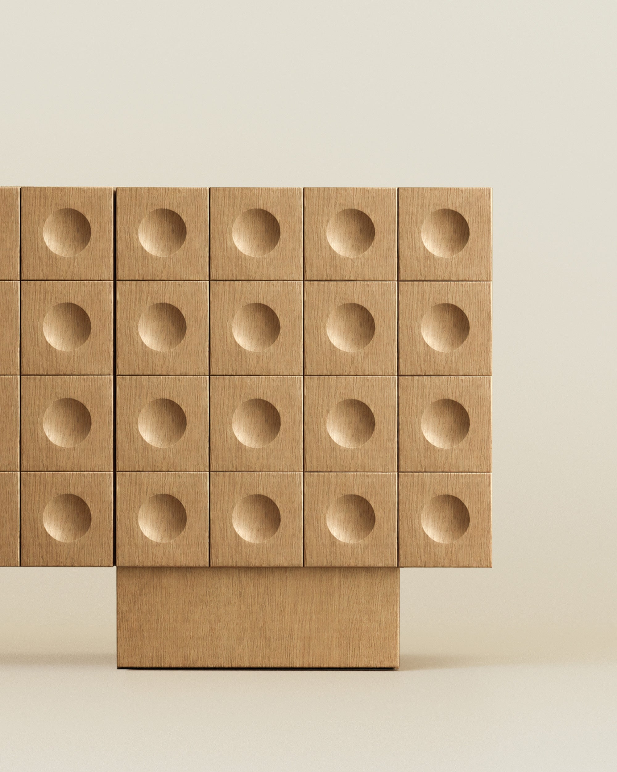 Close-up of a modern wood sideboard with circular indented drawer fronts on a neutral beige background.