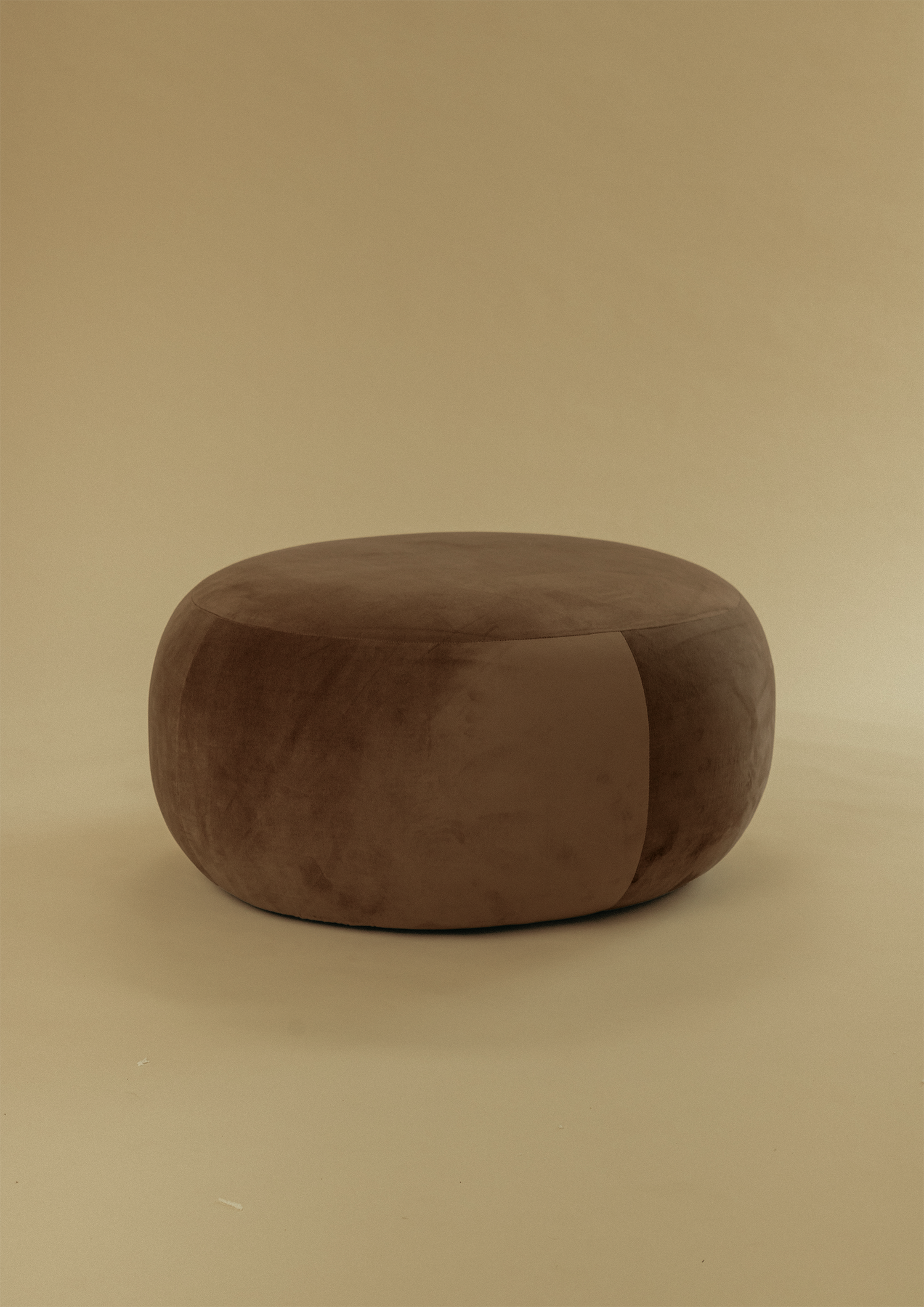 Large Pebble Ottoman in brown upholstery with a rounded silhouette, shown from a front angle on a neutral background.