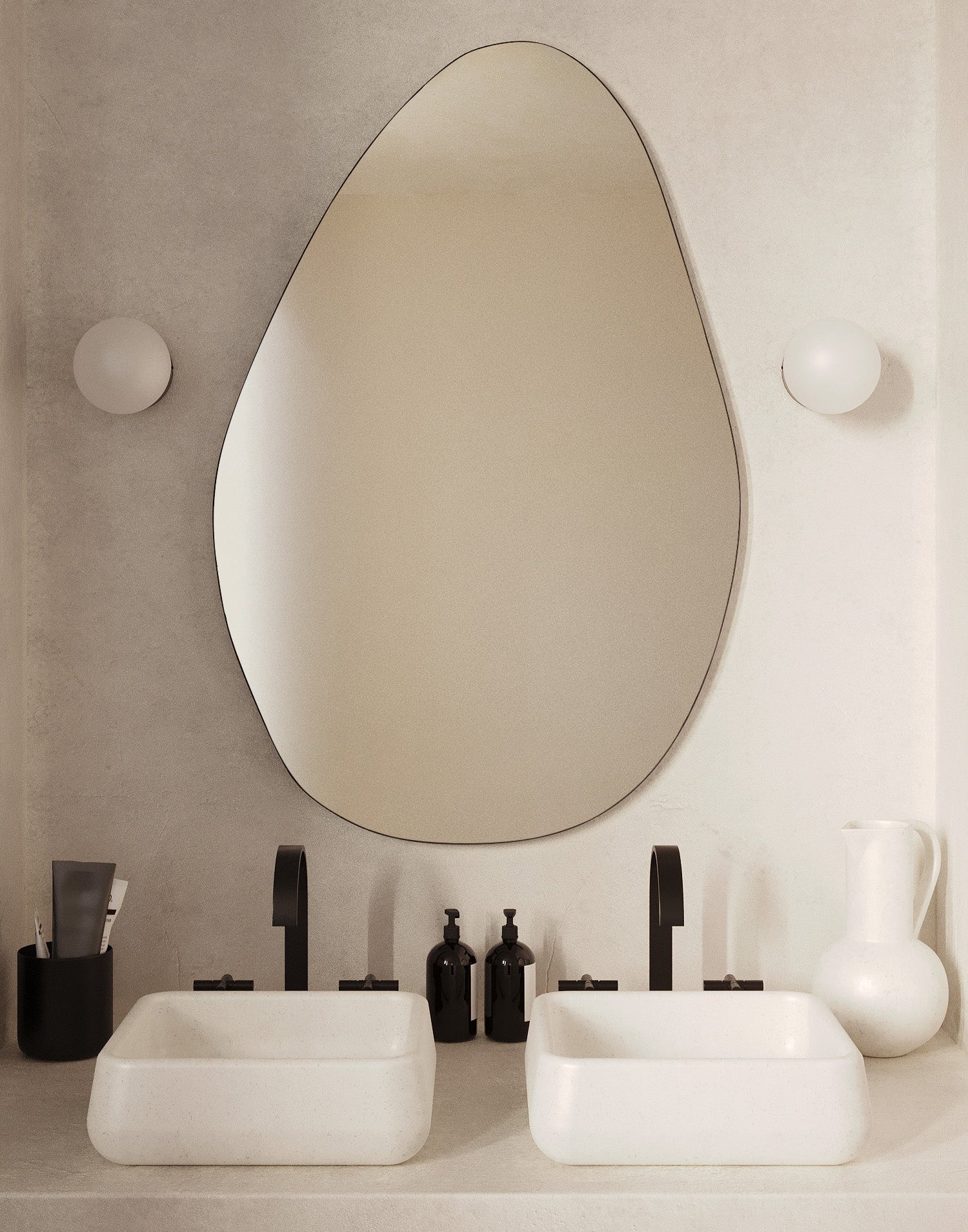 Pebble-shaped frameless wall mirror mounted above a double bathroom vanity.
