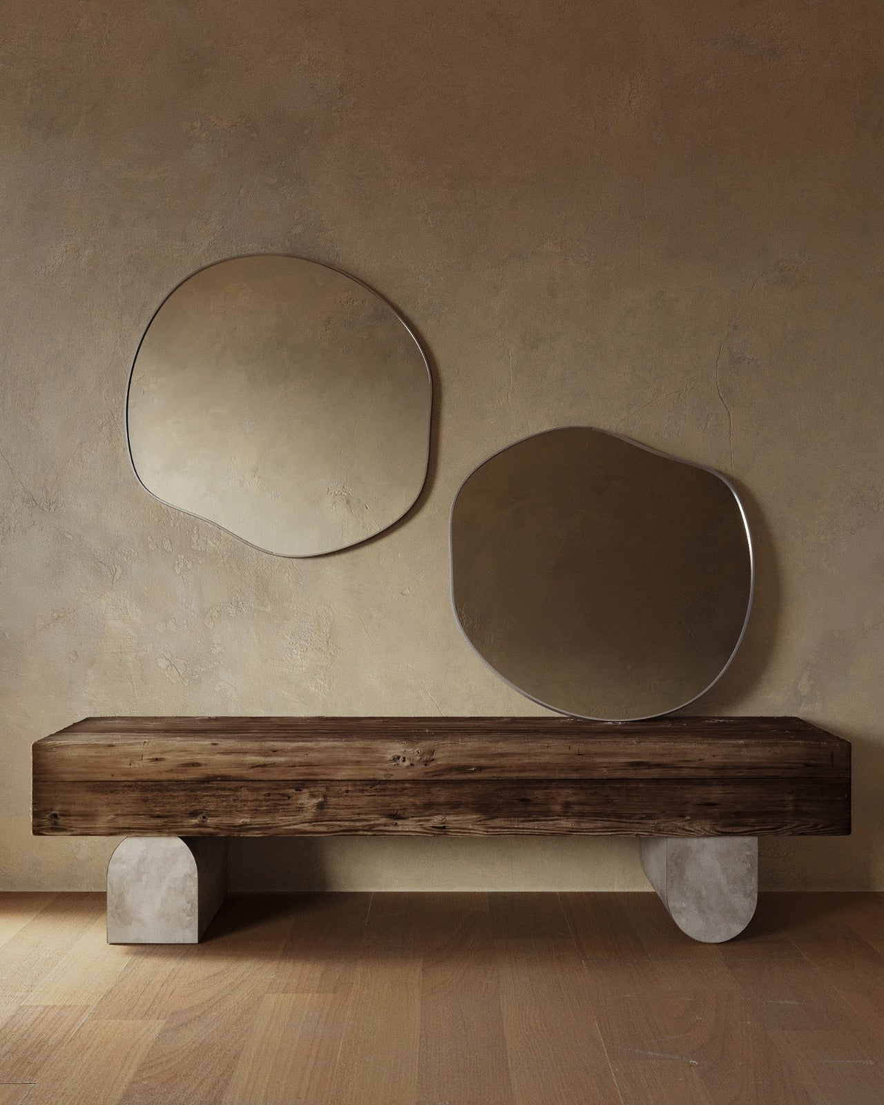 Two organic-shaped wall mirrors with slim stainless steel frames mounted above a wooden bench.