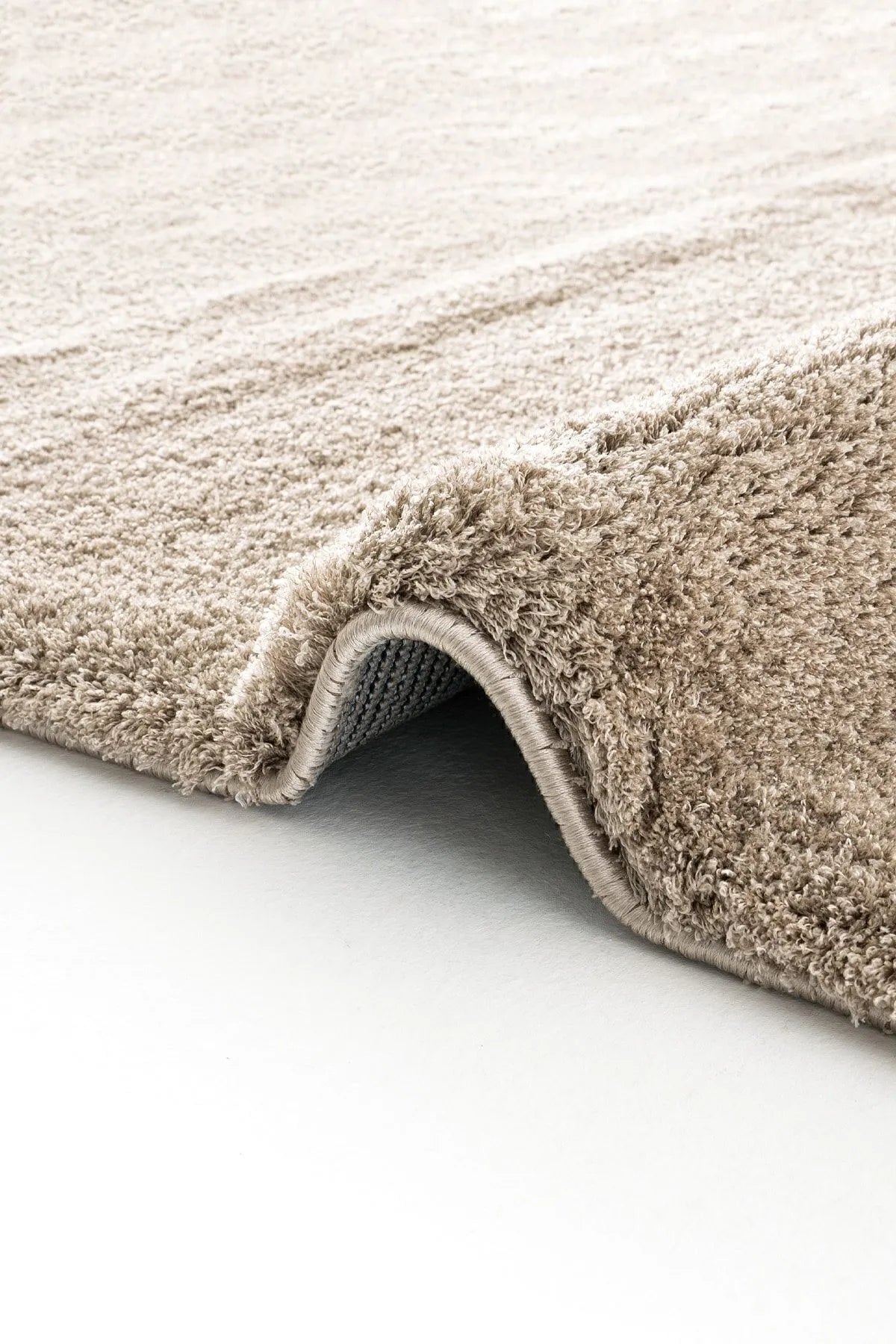 Brown rectangular handcrafted rug with a soft, plush texture and subtle tonal variation.