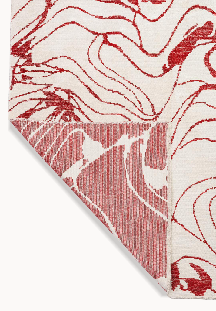 Red abstract rug corner detail.