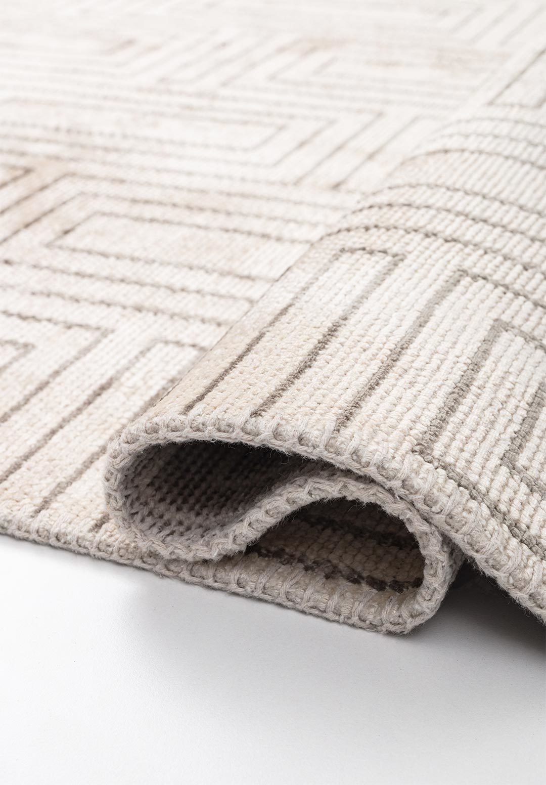 Geometric rug detail with soft neutral tones.