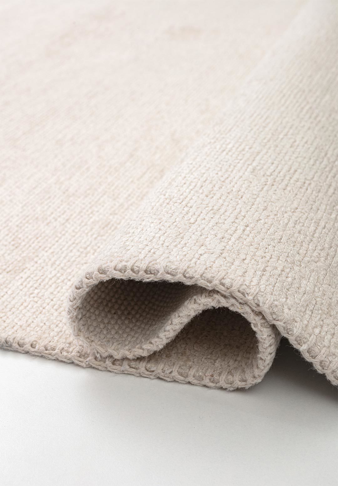 Close-up of almost white flat-woven rug.