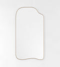 Asymmetrical full-length mirror with an organic shape and thin brass-colored frame on a white background.
