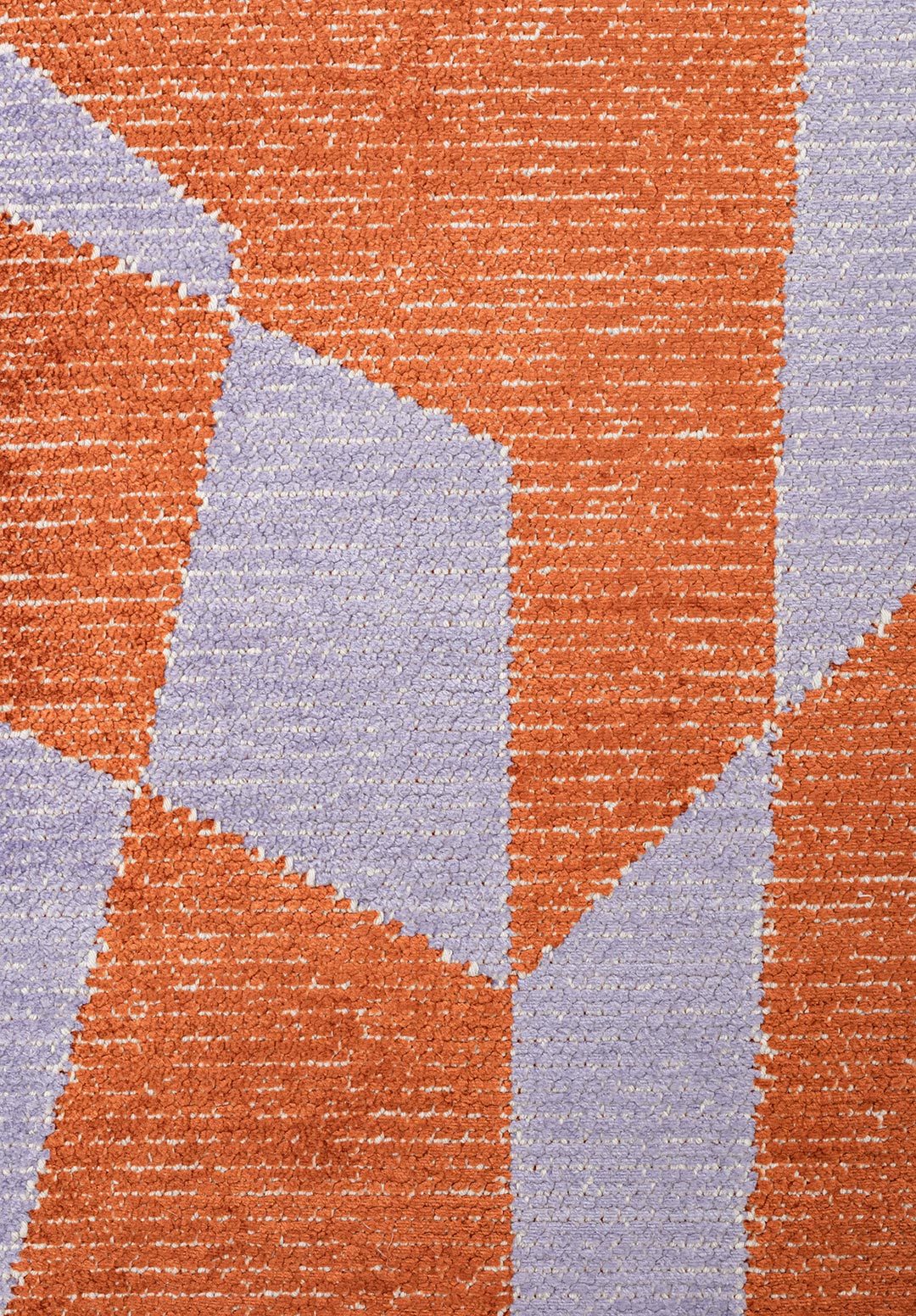 Close-up of an abstract rug with rust and lavender geometric shapes.
