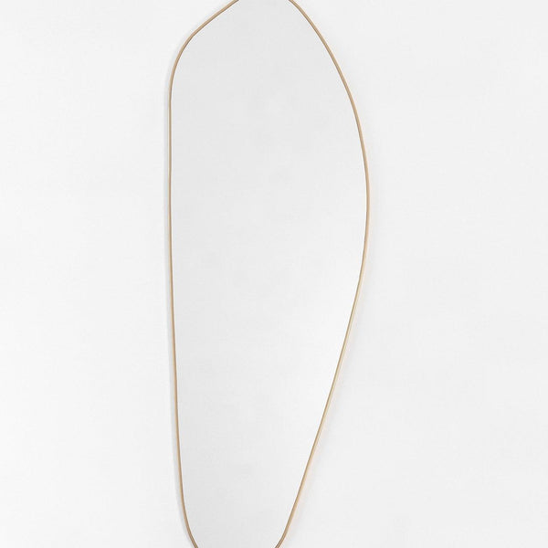 Asymmetrical full-length mirror with a brass frame on a white background.
