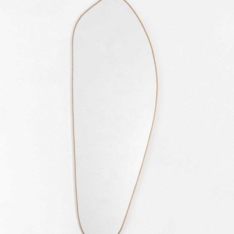 Asymmetrical full-length mirror with a brass frame on a white background.