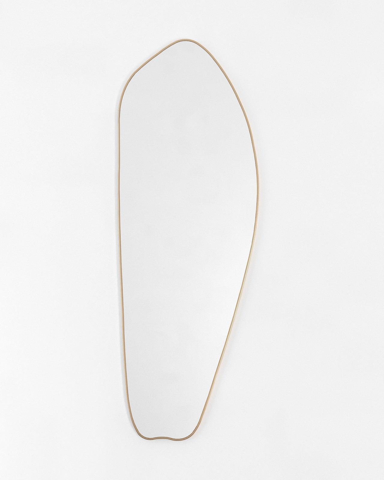 Asymmetrical full-length mirror with a brass frame on a white background.